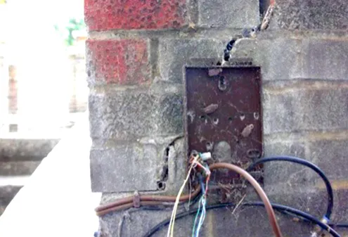 Exposed wiring hanging from an external wall box